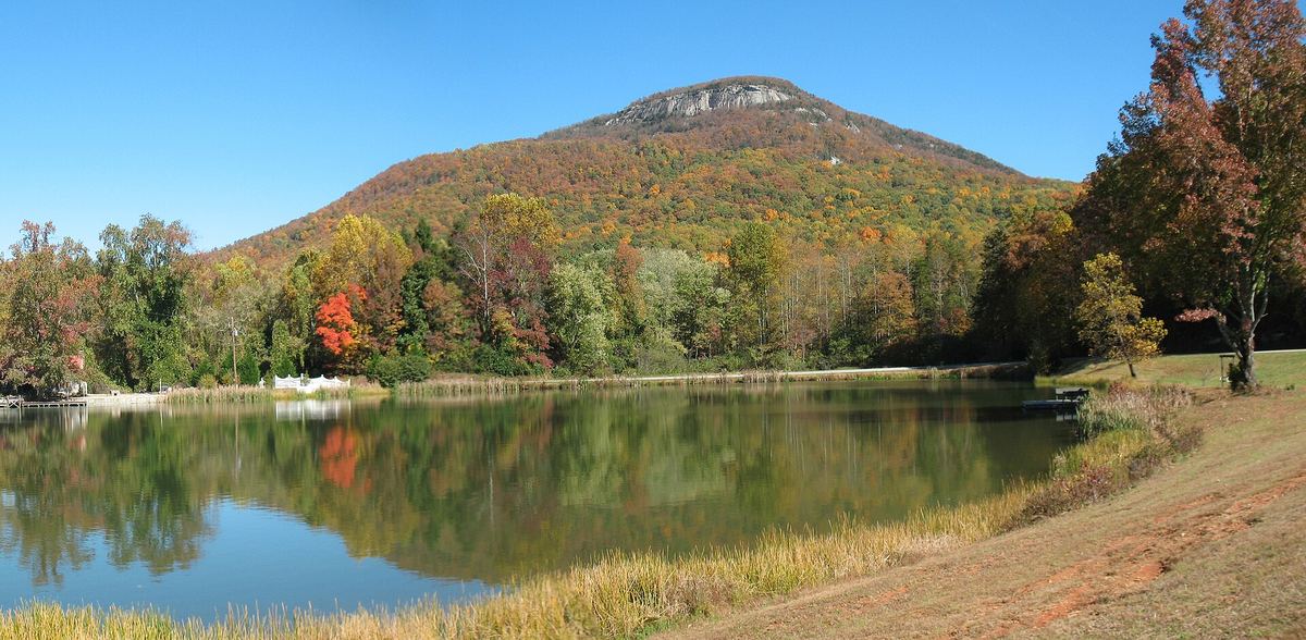 Mount Yonah's rocky summit above autumn trees and a still pond