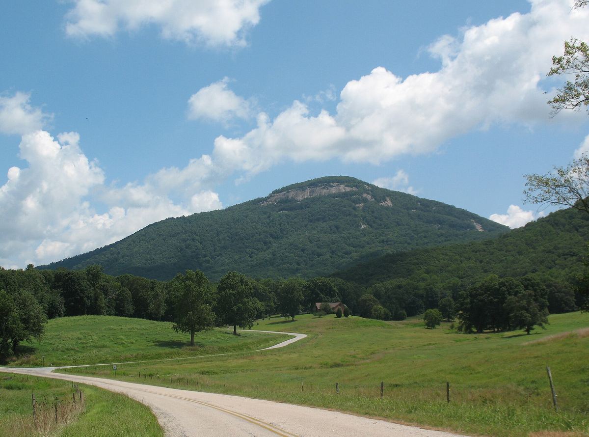 Mount Yonah's rounded, cliff-topped summit rising over green pastures and a country road